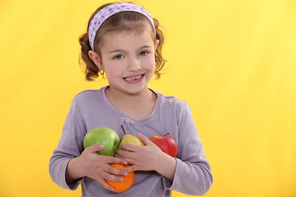 Holčička drží výběr ovoce — Stock fotografie