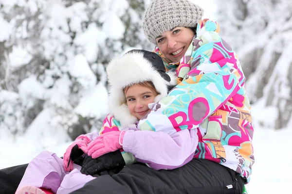 Anne ve kızı birlikte karda oynarken — Stok fotoğraf