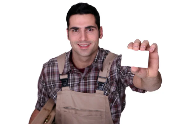 Carpinteiro segurando cartão de visita em branco — Fotografia de Stock