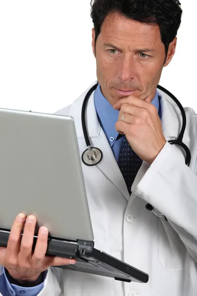 Lekarz martwi się patrząc na laptopa — Zdjęcie stockowe