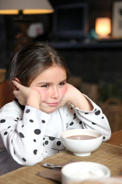 Huysuz küçük kız sıcak çikolata ile oturdu. — Stok fotoğraf