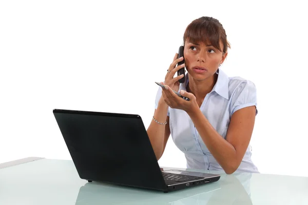 Jonge zakenvrouw met laptop op de telefoon — Stockfoto
