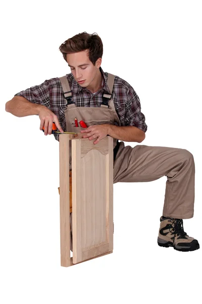 Woodworker agachamento no fundo branco — Fotografia de Stock