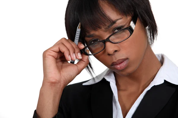 Stern businesswoman touching her glasses — Stock Photo, Image