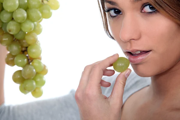 Young woman with bunch of grapes — Stock Photo, Image