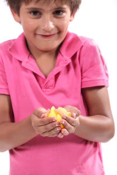 Mały chłopiec trzymając kawałki owoców — Zdjęcie stockowe