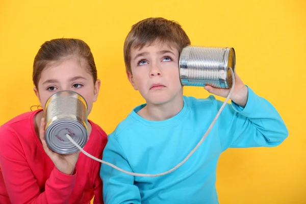 Barn med en plåtburk telefon — Stockfoto
