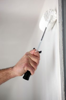 Close-up of man painting wall with roller clipart