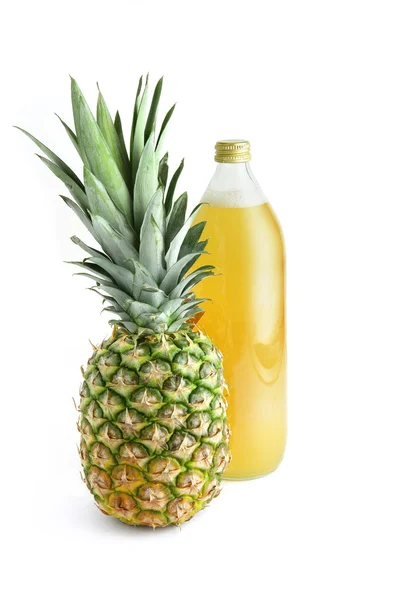 Skleněná láhev šťávy vedle ananas — Stock fotografie