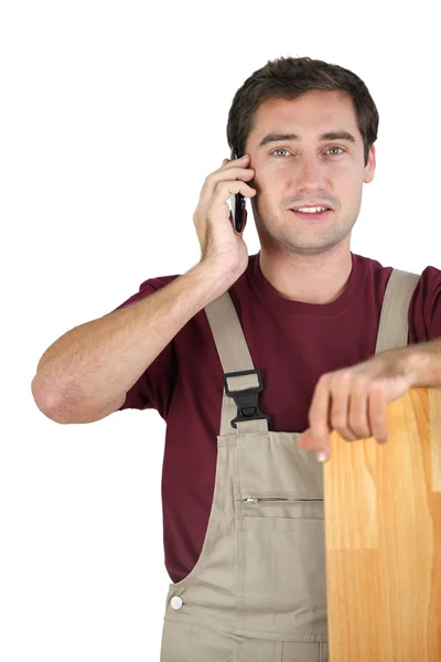 Un carpintero hablando en su teléfono móvil — Foto de Stock