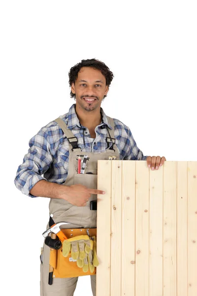 Carpinteiro apontando para painel de madeira — Fotografia de Stock