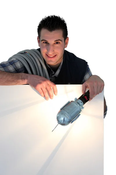 Electrician shining lamp on blank poster — Stock Photo, Image