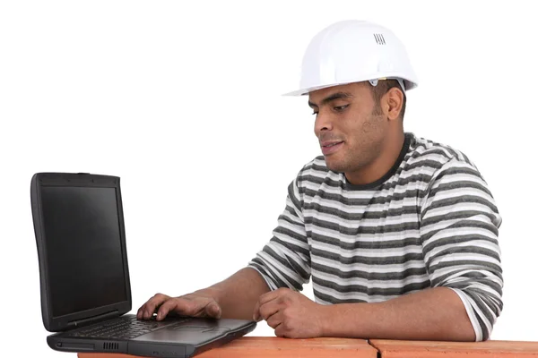 Builder sat using laptop — Stock Photo, Image