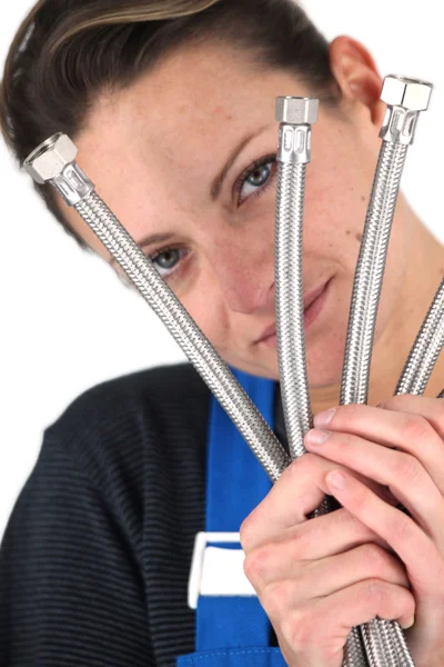 Vrouwelijke loodgieter houden selectie van metalen buizen — Stockfoto