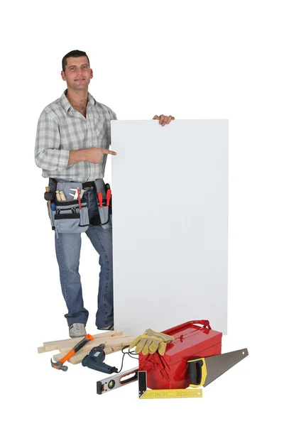 Carpenter stood with blank advertising panel — Stock Photo, Image