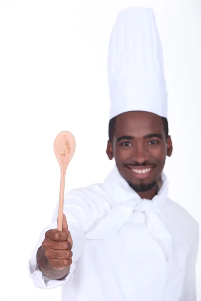 Jovem cozinheiro mostrando colher — Fotografia de Stock