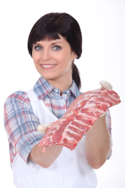 Женщина-мясник стояла с сырым мясом — стоковое фото