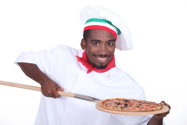Chef italiano com uma pizza em uma casca de madeira — Fotografia de Stock