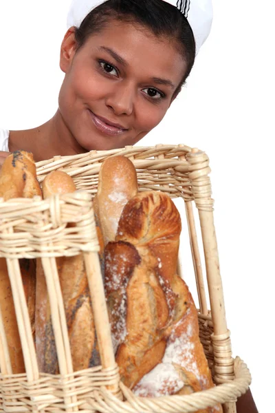 Bakery worker holding basket of bread — Stock Photo, Image