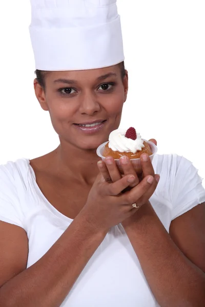 Een vrouwelijke Bakker presenteren een gebak. — Stockfoto