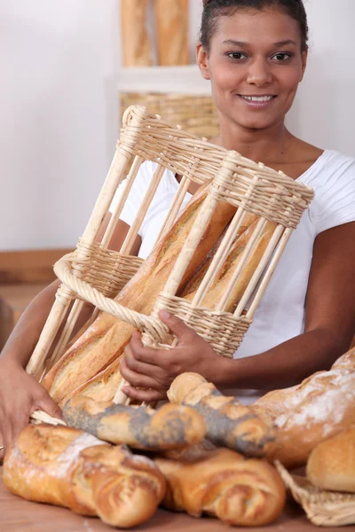Женщина в пекарне с корзиной хлеба — стоковое фото