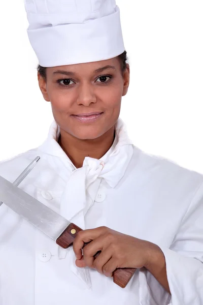 Female chef sharpening a knife — Stock Photo, Image