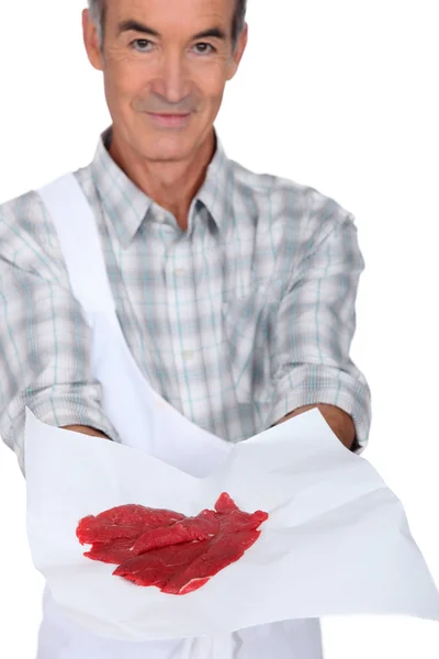 Slaktare visar kött på vit bakgrund — Stockfoto