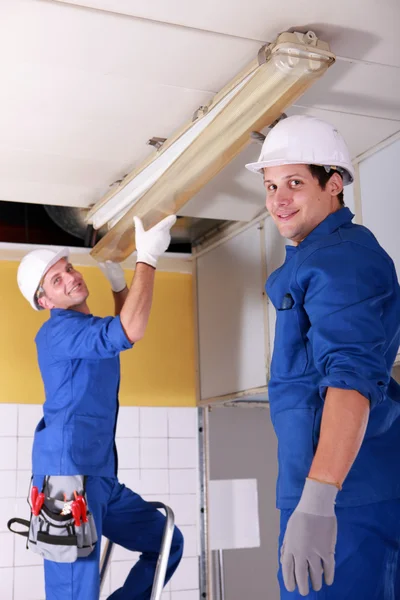 Electricians installing neon lights in the ceiling — Stock Photo, Image