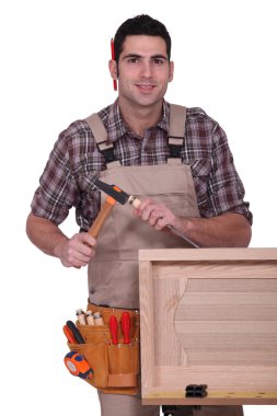 Carpenter with hammer and chisel clipart