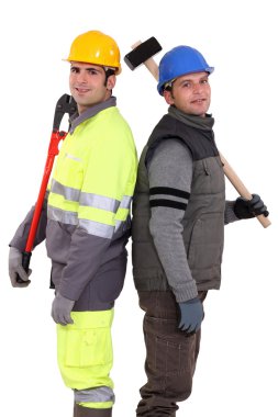 Tradesmen standing back to back and holding tools clipart