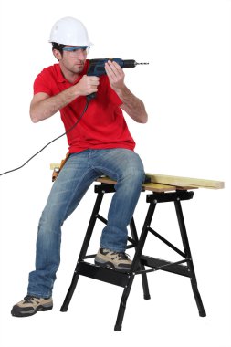 Worker aiming his power drill clipart