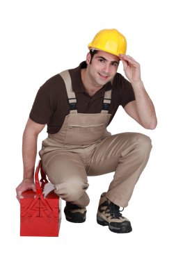 Construction worker posing with his toolbox and wearing a hard hat clipart