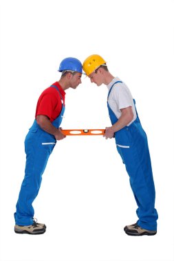 Two craftsmen holding a level clipart