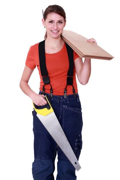 Mujer llevando madera contrachapada y una sierra —  Fotos de Stock