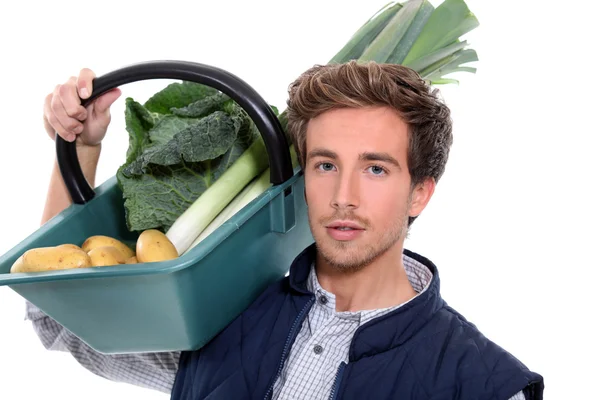 Jeune agriculteur avec un panier de légumes — Photo
