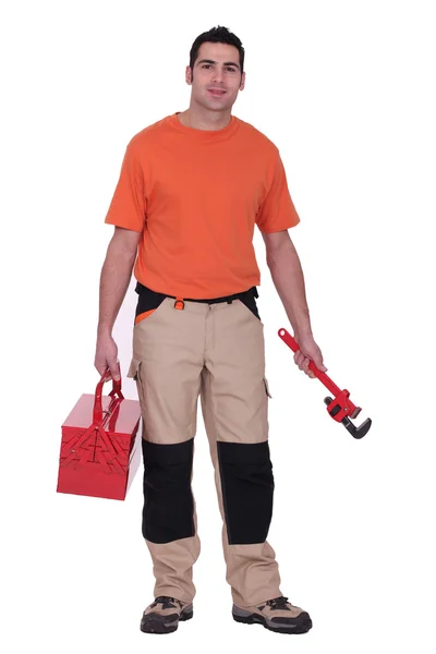 Trabalhador segurando uma chave de tubo e caixa de ferramentas — Fotografia de Stock