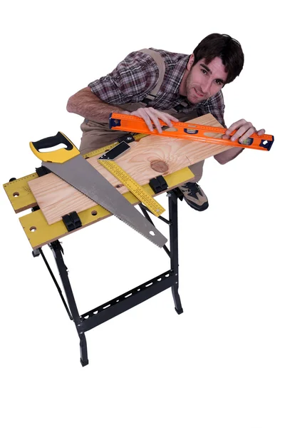 Carpinteiro que trabalha uma prancha . — Fotografia de Stock