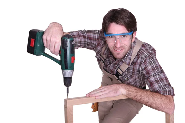 Man drilling into wooden frame — Stock Photo, Image