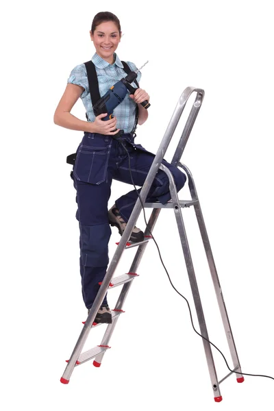 Uma servicewoman com um perfurador em uma escada . — Fotografia de Stock