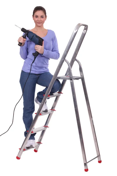 Vrouw stond op de ladder boormachine bedrijf — Stockfoto