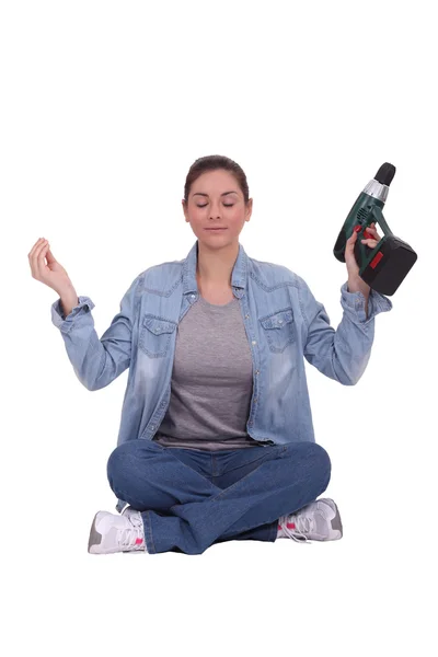 Handwerkerin hält einen Bohrer in der Hand und meditiert — Stockfoto