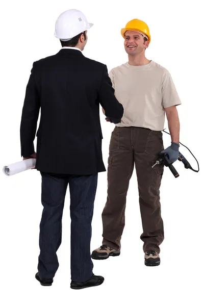 Architect and construction worker shaking hands — Stok fotoğraf