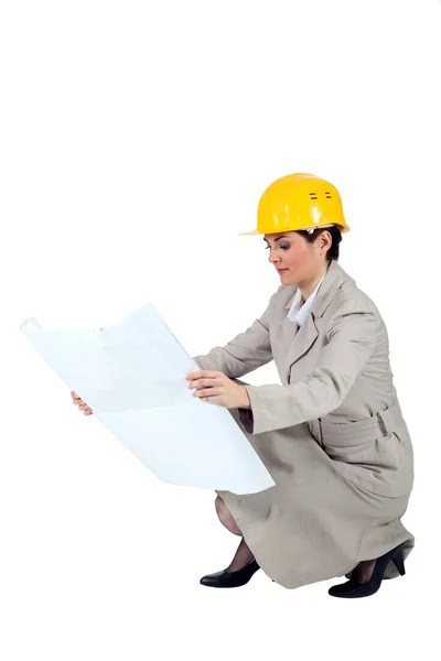 Vrouwelijke ondernemer crouching op witte achtergrond — Stockfoto