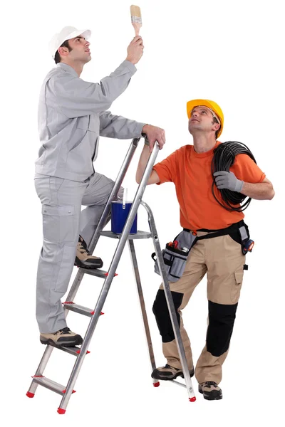 En målare och elektriker ser på taket. — Stockfoto