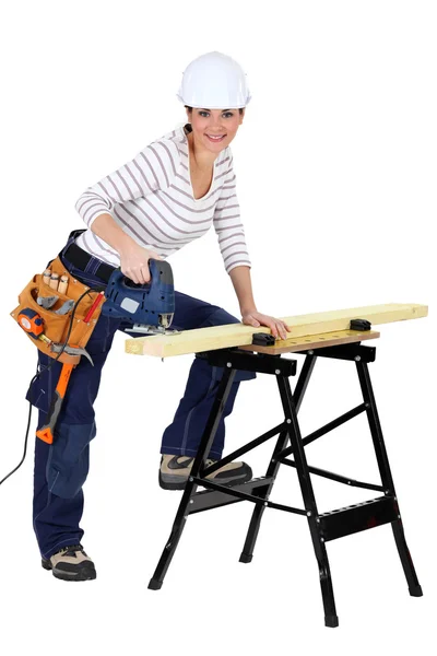 Woman sawing wood with electrical saw — Stock Photo, Image