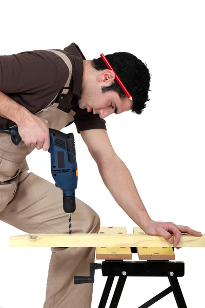 Carpinteiro de perfuração de um pedaço de madeira — Fotografia de Stock