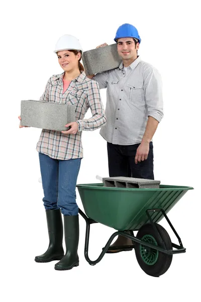 Construction workers carrying cinder blocks — Stock Photo, Image