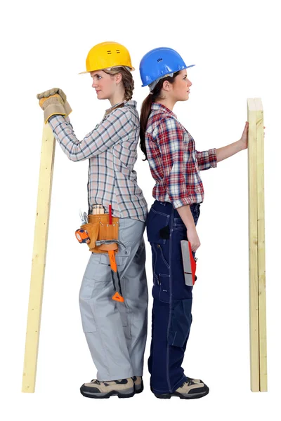 Duo of female carpenters standing back to back in profile — Stock Photo, Image