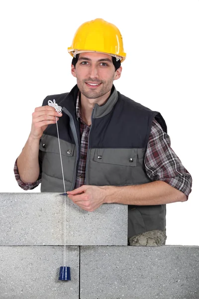 Mason making measurements with a cord — Stock Photo, Image