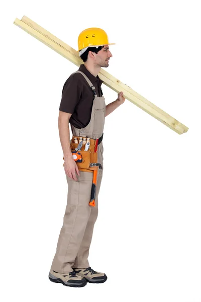 Craftsman carrying two wooden boards on his shoulder — Stock Photo, Image